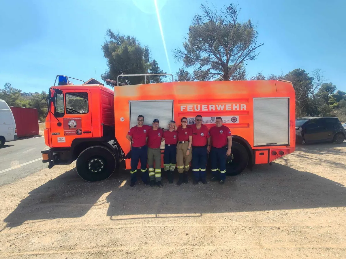 Feuerwehrleute vor einem Feuerwehrauto.